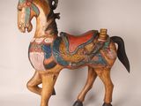 a wooden horse that is standing on a white surface
