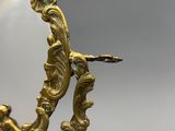 une image représentant un miroir avec un cadre doré sur lequel est représenté un oiseau