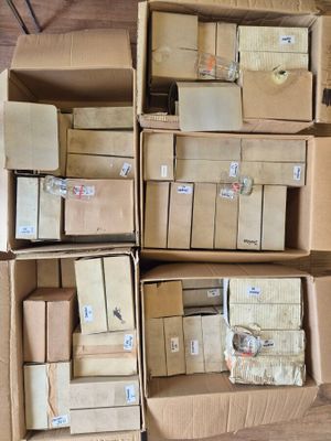 Plusieurs cartons sont empilés les uns sur les autres sur un plancher en bois.