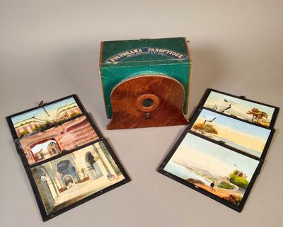 trois cartes illustrées posées sur une table, à côté d'une boîte