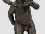 an antique bronze statue of a little boy with a bird on his shoulder