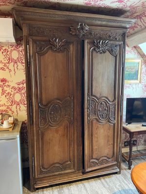 a large wooden armoire in the corner of a room