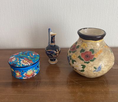 three vases sitting on a wooden table next to each other