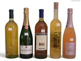 bottles of wine are lined up in a row on a white surface