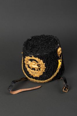 a close up of a black and gold hat on a black background