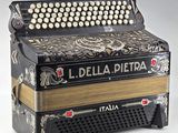 an old black and gold accordion sitting on top of a white table
