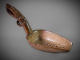an old wooden spoon with a wooden handle on a gray surface