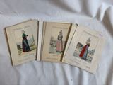 Trois costumes d'époque, pour hommes et pour femmes, sont exposés sur un lit.
