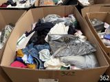 many boxes of clothes that are sitting in a room