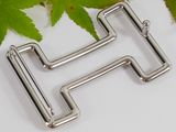 a close up of a metal letter h with leaves in the background