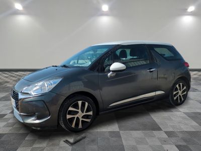 Une Citroën grise est garée sur un sol carrelé à damier.