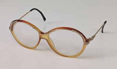 une paire de lunettes posée sur une surface blanche, sur fond blanc