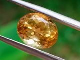 an image of a close up of a yellow diamond being held by a pair of pliers