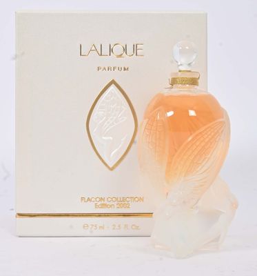 l'image d'un flacon de parfum posé à côté d'une boîte