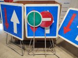 three signs that have arrows on them in front of a box