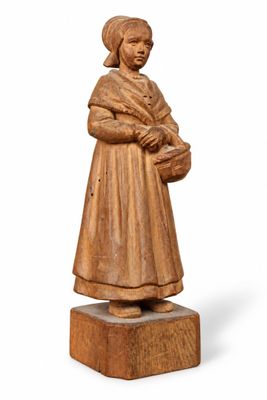 an old wooden statue of a woman holding a basket