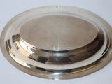 a silver plate with a lid on a white table