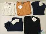 Quatre paires de pulls pour homme sont exposées dans une vitrine.