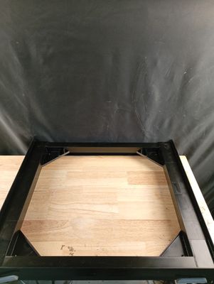 un gros plan d'une table avec un plateau en bois et un piètement en métal