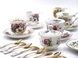 many different types of tea cups and saucers on the table