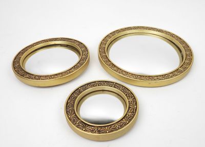 three gold plated mirrors with ornate designs on them on a white surface