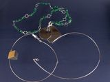 une paire de boucles d'oreilles créoles ornées d'une perle verte