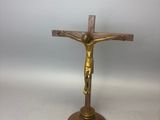 un crucifix en laiton surmonté d'une croix en bois