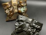 deux masques en bronze et une étoile sur fond noir