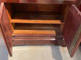 a wooden cabinet with two doors open on the floor