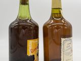 two bottles of wine sitting next to each other on a white surface