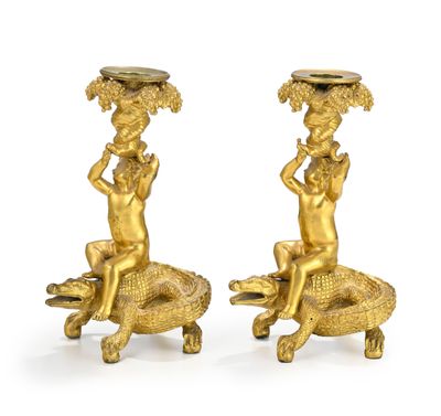 pair of antique brass figurines of a boy and a girl sitting on a crocodile