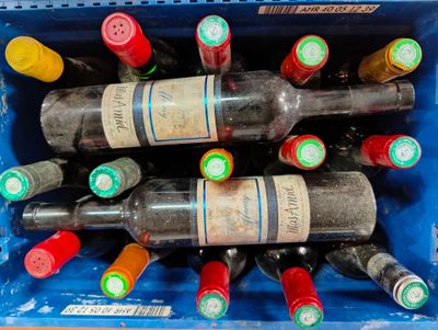 plusieurs bouteilles de vin dans une caisse en plastique bleue