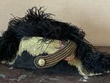 a black and gold hat with feathers on top of a table