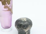 a small vase next to a small vase on a white surface