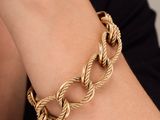 a close up of a woman wearing a gold chain bracelet
