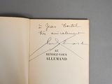 an open book with a handwritten signature on it sitting on top of a table