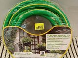 a green hose sitting on top of a white and black striped towel