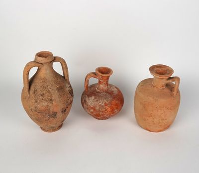 three clay vases are sitting next to each other on a white surface