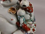 a figurine of a laughing man holding a fish