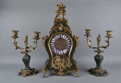 une horloge posée sur une table, avec trois bougies