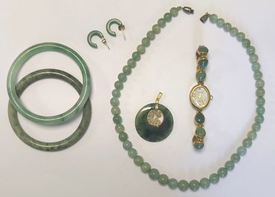 un collier, un bracelet, une bague et d'autres bijoux posés sur une table