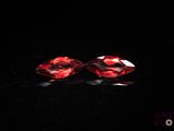 a pair of red diamonds on a black surface
