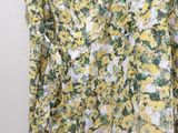 a yellow and white floral dress hanging on a hanger
