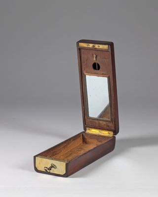 an old wooden box with a mirror on top of it