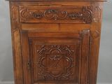 une vieille armoire en bois avec des sculptures et des gravures sur les portes