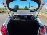 a white car with its trunk open on the street