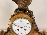 a gold clock with an eagle on top of it