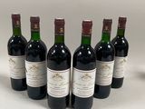 six bouteilles de vin sont alignées sur une table
