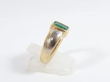an image of a gold ring with a green stone on top of it