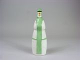 une figurine verte et blanche représentant une femme coiffée d'un chapeau